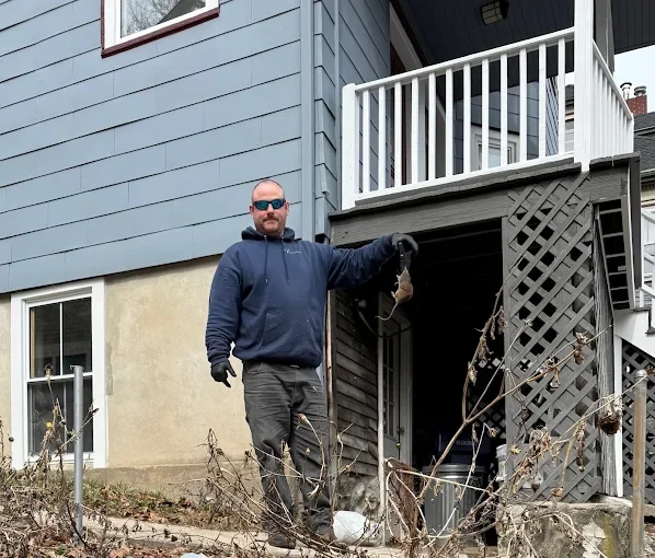 Technician sealing rodent entry points at residential foundation and basement area